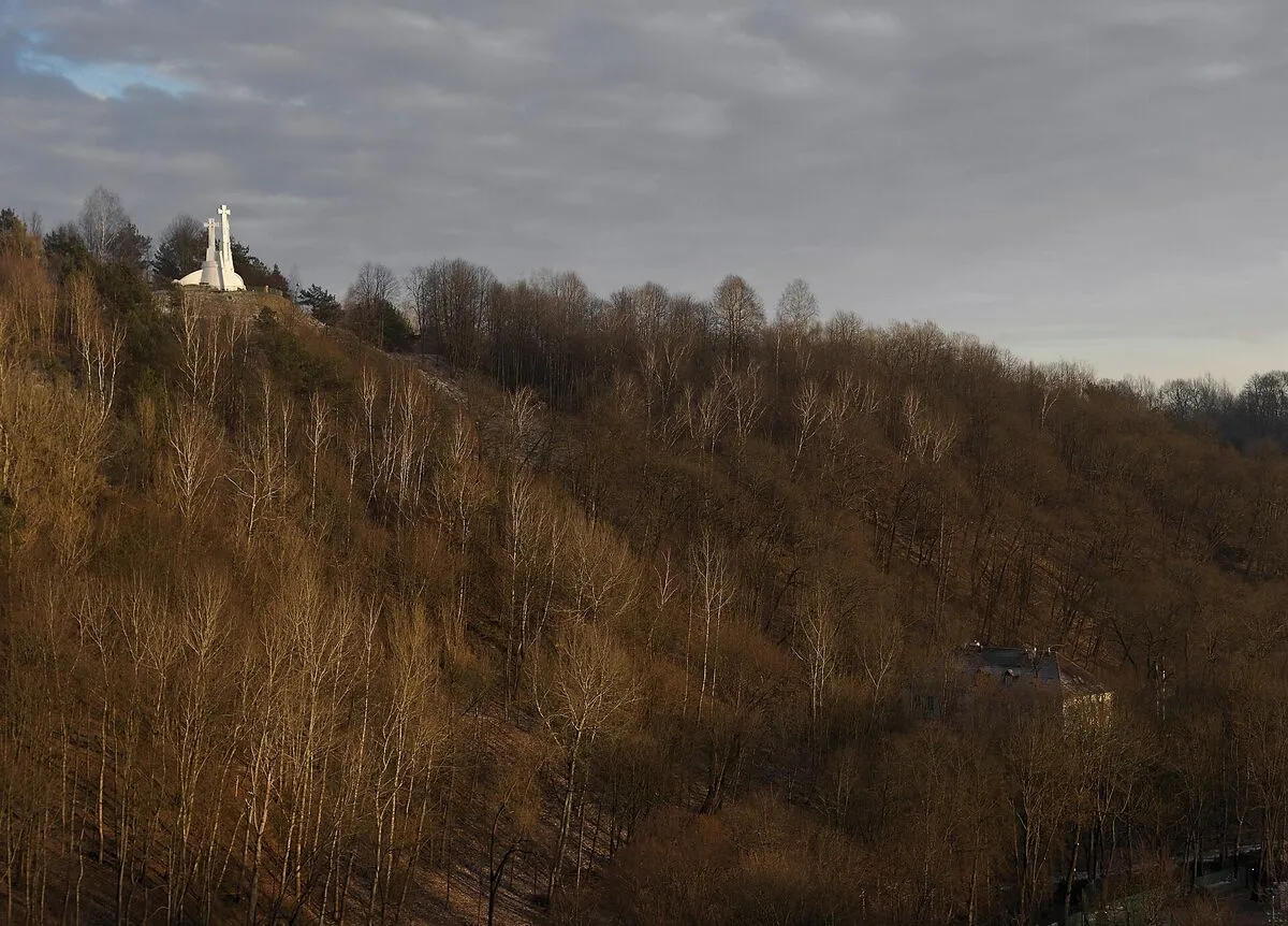 Biały pomnik Trzech Krzyży na zalesionym zboczu Góry Trzykrzyskiej w Wilnie