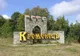 Kamienny znak powitalny w kształcie bramy zamkowej z żółtym napisem Krzemieniec (Кременець)