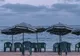 Parasole w biało-zielone pasy i plastikowe krzesła na plaży w Marsa Matruh nad Morzem Śródziemnym