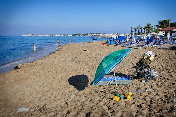 Plaża z parasolem, wózkiem i zabawkami dziecięcymi