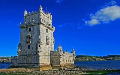 Kamienna Torre de Belém nad brzegiem Tagu w słoneczny dzień
