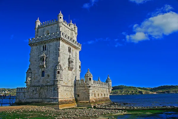 Kamienna Torre de Belém nad brzegiem Tagu w słoneczny dzień