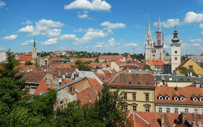 Panorama Zagrzebia z czerwonymi dachami i dwiema wieżami katedry Wniebowzięcia NMP
