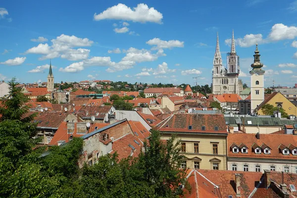 Panorama Zagrzebia z czerwonymi dachami i dwiema wieżami katedry Wniebowzięcia NMP