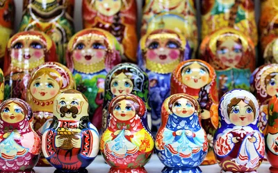 Rzędy kolorowo malowanych drewnianych laleczek na półce sklepu z pamiątkami