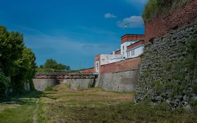 Mury i bastion zamku w Dubnie od strony suchej fosy, w głębi most i budynek bramy