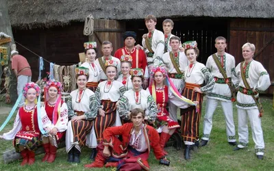 Zespół tańca ludowego w koszulach i bluzkach zdobionych haftem oraz w wiankach