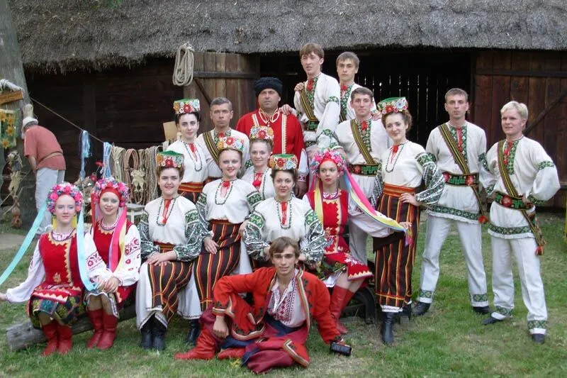 Zespół tańca ludowego w koszulach i bluzkach zdobionych haftem oraz w wiankach