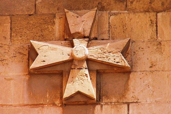 Malta | Jeden z wielu krzyży maltańskich na murach kamienicy